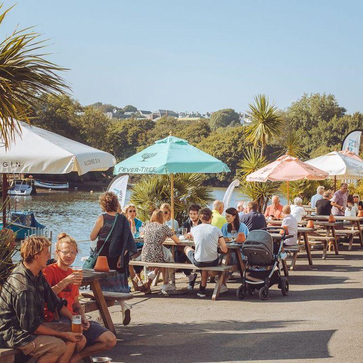 People sat in a pub garden on a riverside