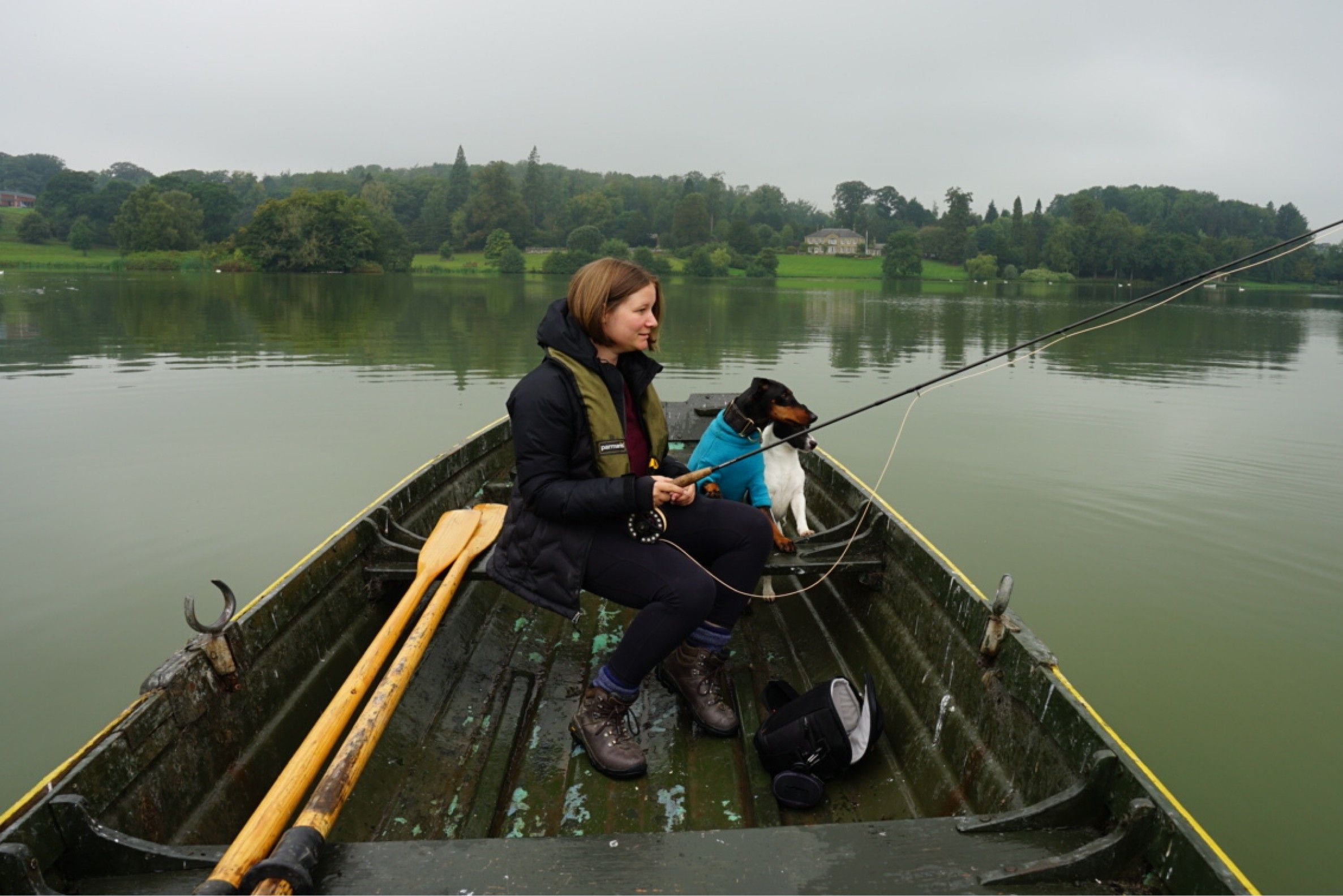 A woman and a dog in a fishing boat